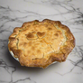 Baked pie with a heart-shaped cutout on a metal surface