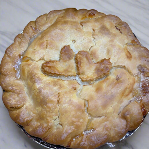 Chicken pot pie with a decorative crust in a cardboard box